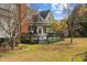 A covered deck is visible on the home's exterior, featuring mature landscaping and a brick chimney at 205 Parliament Pl, Dunn, NC 28334