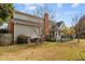 Backyard view of home, with brick chimney, lush landscaping, mature trees, and a spacious deck at 205 Parliament Pl, Dunn, NC 28334