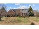 Charming brick home with a welcoming front porch, surrounded by mature trees and well-kept landscaping at 205 Parliament Pl, Dunn, NC 28334