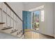 Bright foyer featuring hardwood floors, stairs with carpet, and a stylish teal front door at 205 Parliament Pl, Dunn, NC 28334