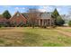 Charming brick home with a well-manicured lawn, complemented by colorful landscaping at 205 Parliament Pl, Dunn, NC 28334
