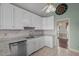 Well-lit kitchen featuring white cabinetry, granite countertops, tile backsplash, and stainless steel dishwasher at 205 Parliament Pl, Dunn, NC 28334