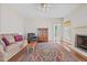 Inviting living room featuring hardwood floors, a fireplace, and comfortable seating with a decorative rug at 205 Parliament Pl, Dunn, NC 28334