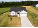 An aerial view of a charming home with an expansive lawn, a two-car garage and long driveway at 207 Golfview Ave, Benson, NC 27504
