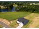 Picturesque aerial view of the gray home near a tranquil pond surrounded by lush greenery at 207 Golfview Ave, Benson, NC 27504
