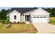Charming single-story home with gray siding, a well-manicured lawn, and an attached two-car garage at 207 Golfview Ave, Benson, NC 27504