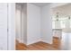 Hallway with wood flooring leads to a bright kitchen and eating area at 207 Golfview Ave, Benson, NC 27504