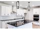 Bright kitchen featuring a large island with a dark granite countertop, black hardware and stainless appliances at 207 Golfview Ave, Benson, NC 27504