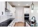Modern kitchen boasts white cabinetry, stainless steel appliances, and sleek black countertops at 207 Golfview Ave, Benson, NC 27504