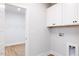 Functional laundry room features white cabinets, washer hookups, and access to a closet at 207 Golfview Ave, Benson, NC 27504