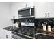 Close-up of gas cooktop with black splash, stainless steel microwave and white cabinets at 208 Martin Luther King Jr Blvd, Raleigh, NC 27601