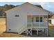 View of a backyard with a covered deck, stairs leading down to the grassy yard, and white siding at 228 Pecan Valley Way, Four Oaks, NC 27524