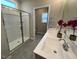 Bathroom featuring a double sink vanity, tiled floors, and a glass-enclosed shower at 228 Pecan Valley Way, Four Oaks, NC 27524