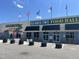Vibrant food hall exterior with colorful flags, mural, outdoor seating and visible parking at 228 Pecan Valley Way, Four Oaks, NC 27524