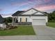 Charming single-Gathering home showcasing a well-manicured lawn, two car garage, and stone accents at 228 Pecan Valley Way, Four Oaks, NC 27524