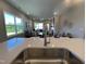 Modern kitchen with stainless faucet, open to a spacious living area with a fireplace and ample natural light at 228 Pecan Valley Way, Four Oaks, NC 27524
