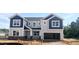 New two-story home featuring blue and gray siding, a stone foundation, and an attached two-car garage at 245 Golfview Ave, Benson, NC 27504