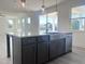 Modern kitchen island featuring dark cabinetry, light countertops, and stainless steel farmhouse sink at 245 Golfview Ave, Benson, NC 27504