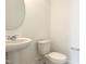 Powder room featuring a pedestal sink, toilet, and a round mirror at 245 Golfview Ave, Benson, NC 27504