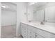 Bathroom with dual sinks, white cabinets, granite countertops, modern faucets, and a large mirror at 2915 Huxley Way, Apex, NC 27502