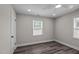 Bright bedroom featuring modern vinyl plank flooring, ceiling fan, and two windows at 3005 Lewy Ln, Rocky Mount, NC 27801