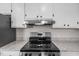 Close up of the stainless steel stovetop and hood, set against granite countertops and white cabinets at 3005 Lewy Ln, Rocky Mount, NC 27801