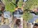 An aerial view of a home with a dark roof, mature trees, and a backyard patio area at 308 Burnt Pine Ct, Apex, NC 27502