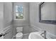 Charming half bathroom with gray walls, patterned tile, and decorative framed mirror at 308 Burnt Pine Ct, Apex, NC 27502
