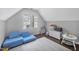 Bright bedroom features a window, blue sofa and toy box for comfortable playtime at 308 Burnt Pine Ct, Apex, NC 27502