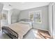 Bedroom features a black metal bedframe, hardwood floors and large windows at 308 Burnt Pine Ct, Apex, NC 27502