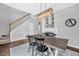 Contemporary dining area adjacent to a staircase, featuring a fireplace and a stylish light fixture at 308 Burnt Pine Ct, Apex, NC 27502