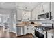 Well-lit kitchen with white cabinets, granite countertops, stainless steel appliances, and dark hardwood floors at 308 Burnt Pine Ct, Apex, NC 27502