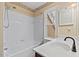 Bathroom with tub and shower combo, single sink vanity, and natural light from window at 3207 Coachmans Way, Durham, NC 27705