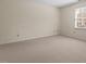 Spacious bedroom with neutral carpet and a large window providing natural light at 3207 Coachmans Way, Durham, NC 27705