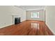 Bright living room with fireplace, hardwood floors, and a large window at 3207 Coachmans Way, Durham, NC 27705