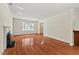 Open living room with a fireplace, hardwood floors, and large window for natural light at 3207 Coachmans Way, Durham, NC 27705