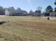 Wide shot showing the house, outbuildings, and a large backyard with varying grass conditions at 3226 Powhatan Rd, Clayton, NC 27527