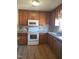 Well-lit kitchen with wooden cabinets, laminate counters, and white appliances at 3226 Powhatan Rd, Clayton, NC 27527