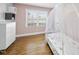 A bedroom with a white framed bed and pink walls is naturally lit from a large window at 352 Leonard Rd, Louisburg, NC 27549