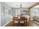 Bright dining room with hardwood floors, wooden table, decorative light fixture, and views of the yard at 352 Leonard Rd, Louisburg, NC 27549