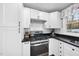 Bright corner of the kitchen featuring stainless steel appliances, granite counters, white cabinets and a window at 352 Leonard Rd, Louisburg, NC 27549