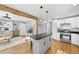 Modern kitchen with white cabinets, island with black countertop, and hardwood floors at 352 Leonard Rd, Louisburg, NC 27549