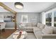 Bright living room with hardwood floors, exposed beam, large sectional sofa, and natural light at 352 Leonard Rd, Louisburg, NC 27549
