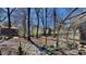 Large landscaped backyard with mature trees, garden beds and partial view of cage at 3704 Sky Meadow Dr, Apex, NC 27539