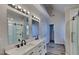 Bright bathroom features a double vanity with modern fixtures, quartz countertops and a sliding glass shower at 3704 Sky Meadow Dr, Apex, NC 27539