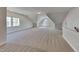 Expansive bonus room features neutral colored carpet and paint, with good natural light from multiple windows at 3704 Sky Meadow Dr, Apex, NC 27539