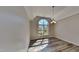 Elegant dining room with a large arched window, modern light fixture, and gray floors creating an airy space at 3704 Sky Meadow Dr, Apex, NC 27539