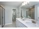 Modern bathroom featuring double sinks, white cabinets, quartz countertops, and tiled walk-in shower at 373 Fosterton Cottage Way, Raleigh, NC 27603