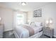 Cozy bedroom featuring a soft color palette, large window, stylish decor, and a comfortable bed at 373 Fosterton Cottage Way, Raleigh, NC 27603