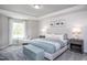 Beautiful bedroom with a large window, tray ceiling, and a stylish upholstered headboard at 373 Fosterton Cottage Way, Raleigh, NC 27603